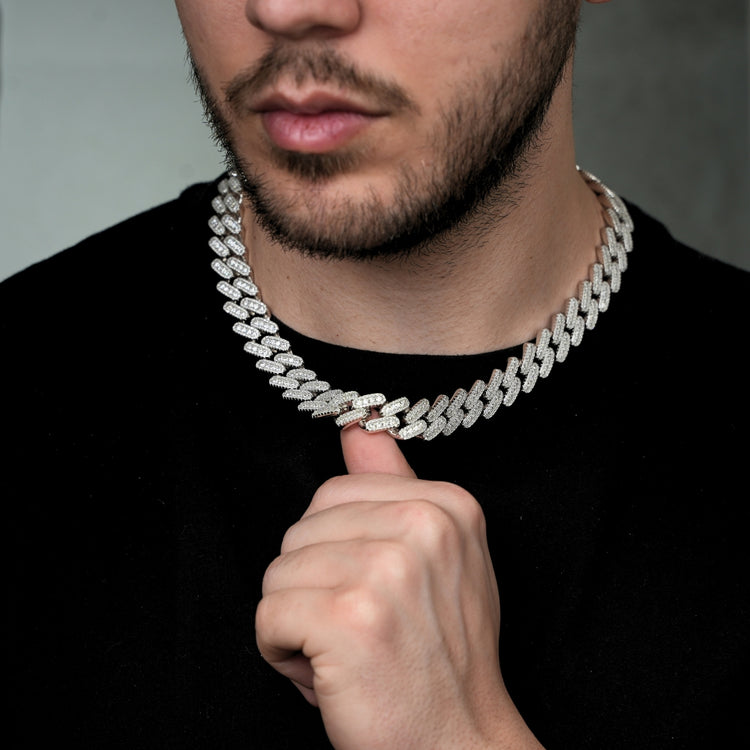 A man with a trimmed beard in a black shirt wears the 12mm-15mm Moissanite Cuban Link Chain in 925 sterling silver around his neck.
