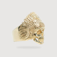 The Native Skull Men Ring – Solid 14K Gold showcases a detailed skull with a feathered headdress, displayed against a plain light background.
