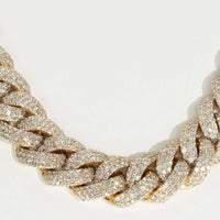 A close-up of the Natural Diamond Cuban Link Chain - 13mm, crafted in 10k solid gold and encrusted with sparkling natural diamonds, shown on a light, neutral background.