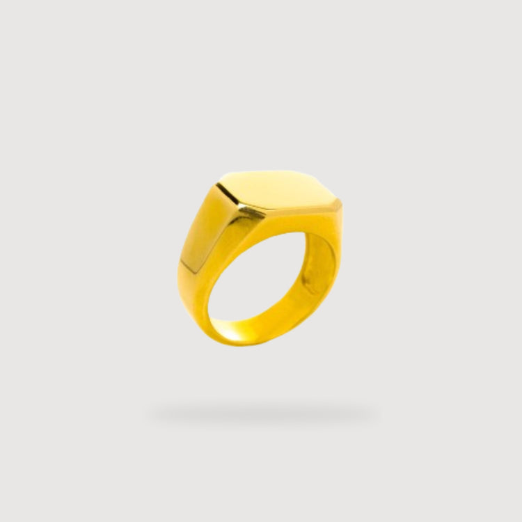 The Octagon Signet Ring in Solid Gold, featuring a flat, smooth top, is centered and appears to float above a soft shadow against a plain light gray background.