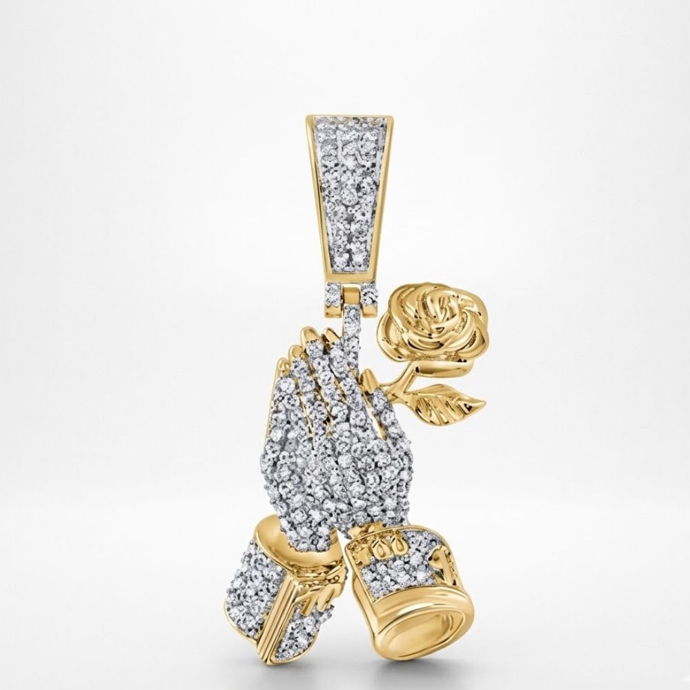 The Diamond Praying Hands Rose Charm 1/2CT 10K Gold features two hands holding a rose, all encrusted with diamonds. This pendant shines luxuriously in yellow gold against a plain white background.