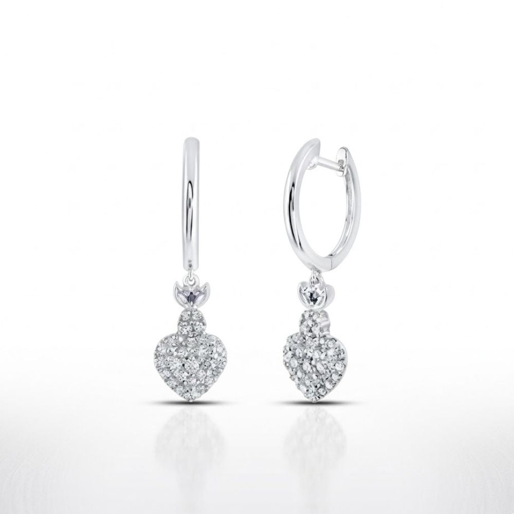 The 14K White Gold Diamond Heart Hoop Dangle Earrings feature heart-shaped charms encrusted with sparkling diamonds, elegantly displayed on a white background.