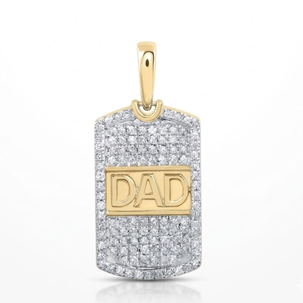 The 10K Yellow Gold Diamond Dad Pendant 1/3 CTW features "DAD" in raised gold letters, accented with small diamonds and a gold bail for attaching to a chain, set against a silver-tone background.