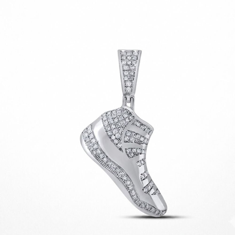 The Sterling Silver Diamond Shoe Pendant 1/2 CTW, designed like a sneaker and set with dazzling diamonds, shines as bold fashion jewelry against a plain white background.