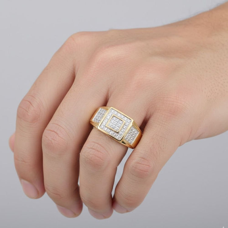 A close-up of a hand wearing the 10K Yellow Gold Diamond Square Ring 1/4CT, showcasing its bold square design set with sparkling diamonds, set against a plain light gray background.