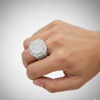 A hand displays the stunning Iced-Out Octagon Cluster Ring - 6.04 CT in 14k White Gold, featuring clusters of sparkling diamonds, set against a plain light background.