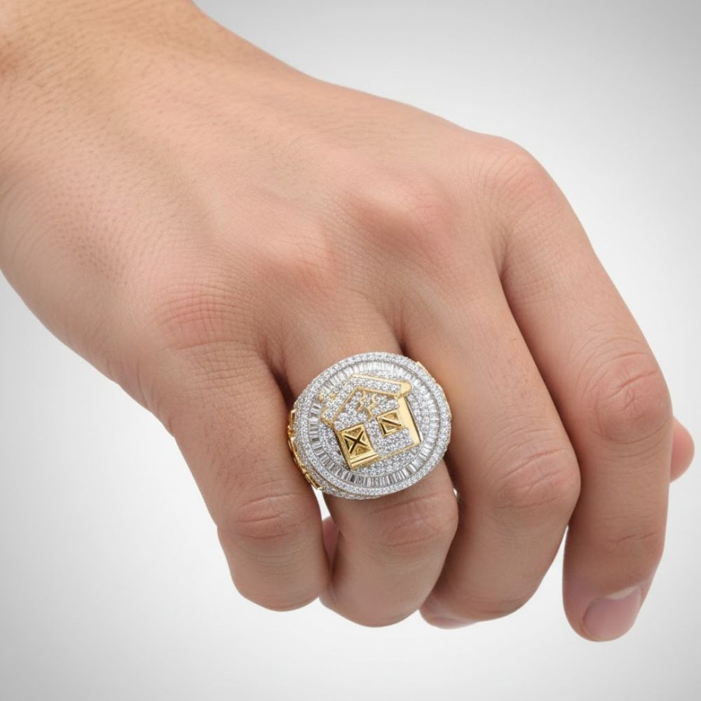 A close-up of a hand wearing the 2 7/8CTW Diamond Trap House Men’s Ring, crafted in 10k gold with natural diamonds and an ornate square and compass design on top.