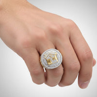 A close-up of a hand wearing the 2 7/8CTW Diamond Trap House Men’s Ring, crafted in 10k gold with natural diamonds and an ornate square and compass design on top.