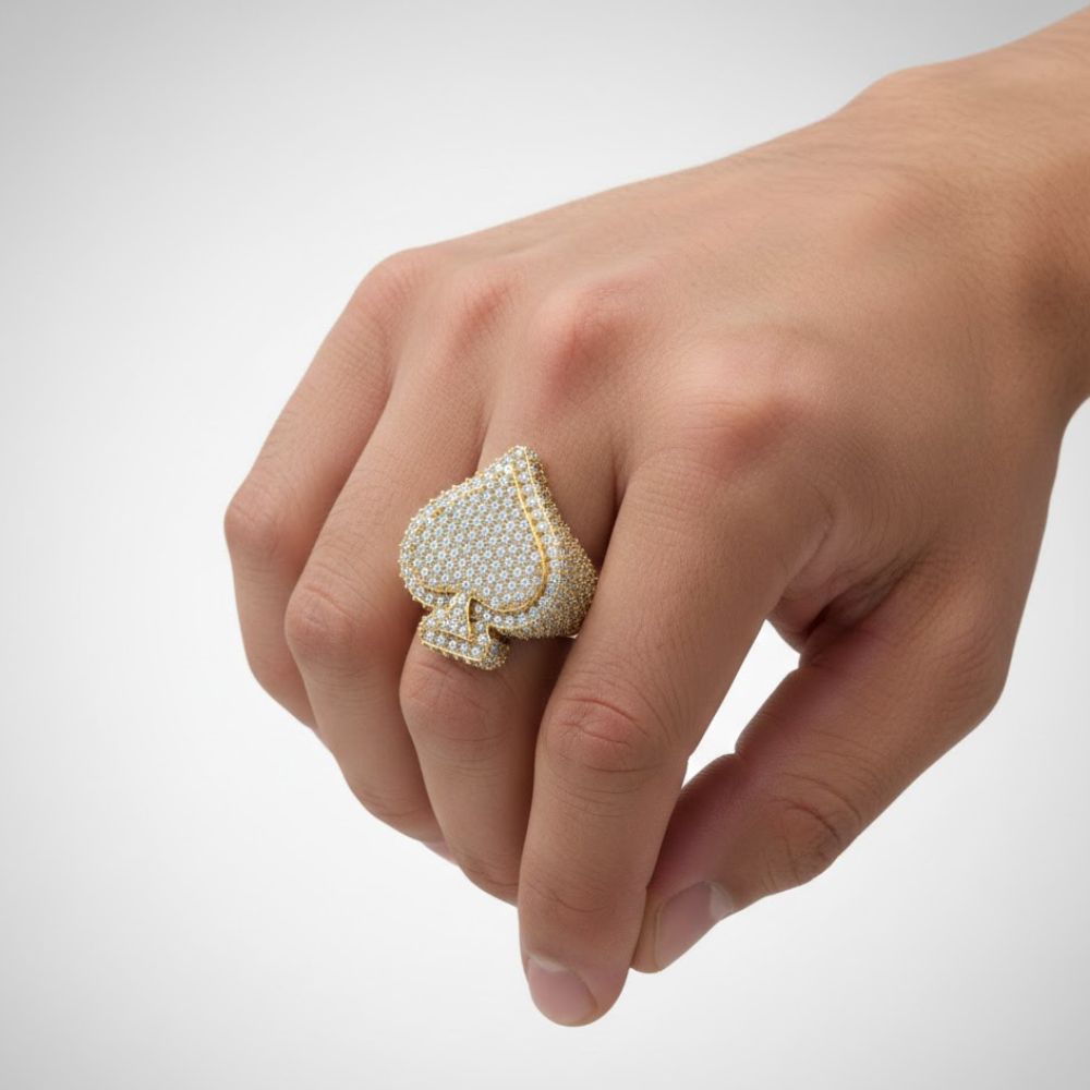 A hand displays the Ace of Spades Diamond Ring – 6.08 CT Pavé Elegance, showcasing a bold spade-shaped design set with sparkling pavé diamonds against a simple light background.