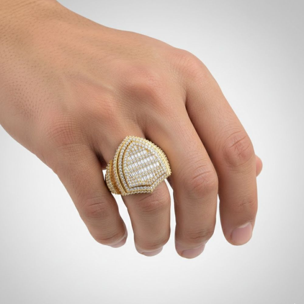 A hand wears the Shield Diamond Ring – 1.13 CT Baguette Design, showcasing a striking geometric pattern with small diamonds and baguette accents—an ideal statement ring for men.