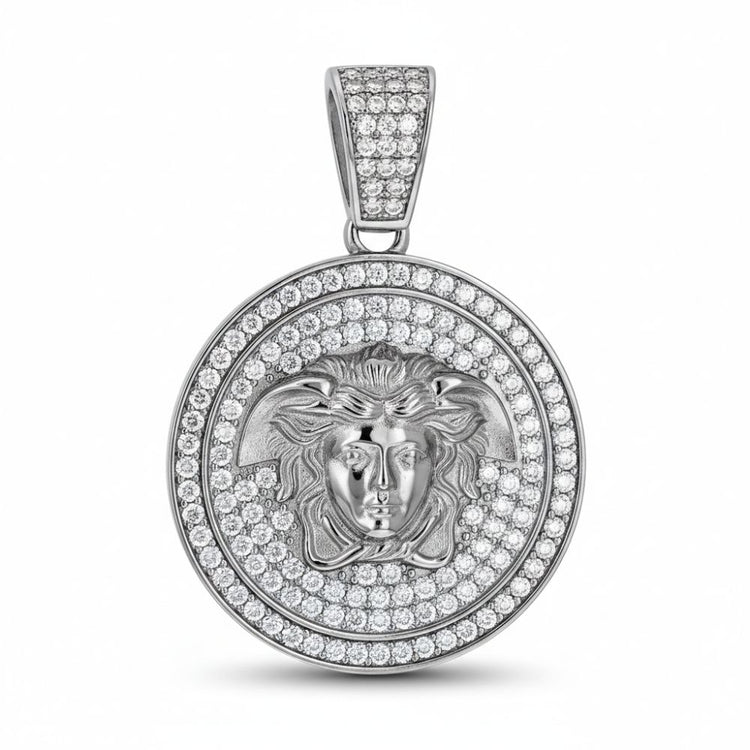 The Moissanite Medusa Egyptian Charm Pendant features a round sterling silver design with a raised classical face and flowing hair, accented by sparkling moissanite stones on both the pendant and bail for added brilliance.