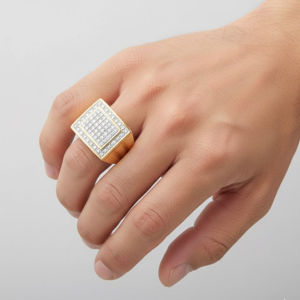A hand displays the 10k Yellow Gold Diamond Square Ring 1/2 CT, featuring multiple rows of sparkling white diamonds in a square design, set in 10k yellow gold against a plain light background.