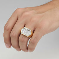 A hand displays the 10k Yellow Gold Round Diamond Rectangle Arched Cluster Ring (1/2 Cttw), featuring a bold rectangular face encrusted with diamonds and shimmering edge accents, set against a plain light background.