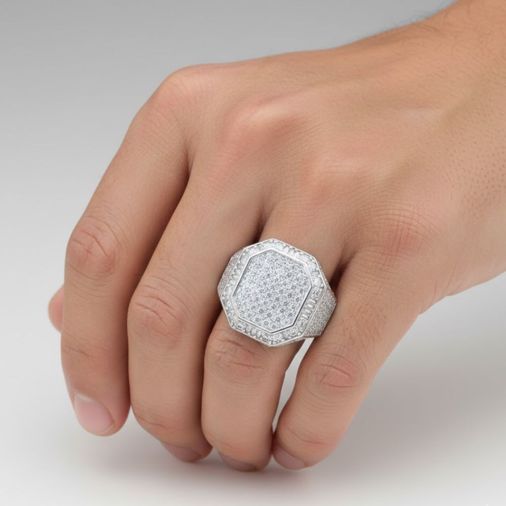 A hand displays the Round Moissanite Octagon Head Fashion Ring, featuring a striking octagon-shaped silver band set with multiple sparkling moissanite stones against a plain light background.