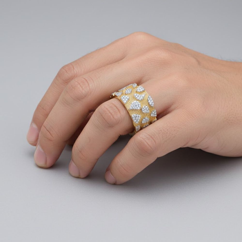 A hand rests on a gray surface, wearing the 5/8CTW Natural Diamond Men's Nugget Ring in 10K gold, featuring sparkling natural diamonds set in a bold nugget design.