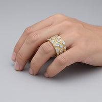 A hand rests on a gray surface, wearing the 5/8CTW Natural Diamond Men's Nugget Ring in 10K gold, featuring sparkling natural diamonds set in a bold nugget design.