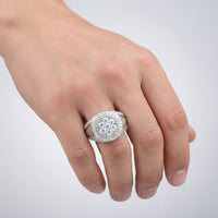 A hand with light skin tone wears a large Moissanite Round Head Fashion Ring, featuring a sterling silver band adorned with multiple small stones on the ring finger, set against a plain, light background.