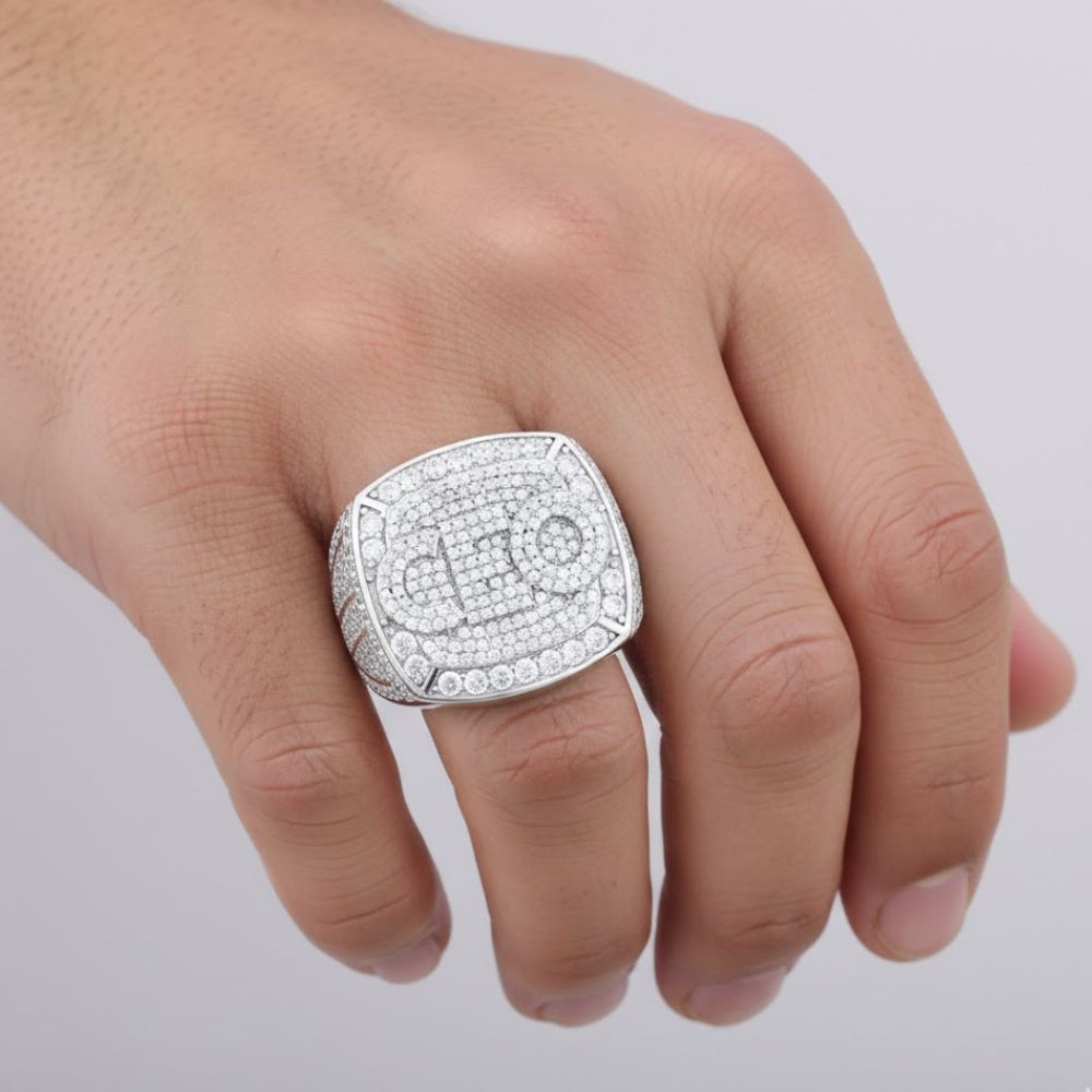 A hand showcases the Baguette Moissanite CEO Square Head Fashion Ring, featuring dazzling small stones, against a simple light background.