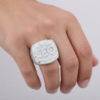 A hand showcases the Baguette Moissanite CEO Square Head Fashion Ring, featuring dazzling small stones, against a simple light background.