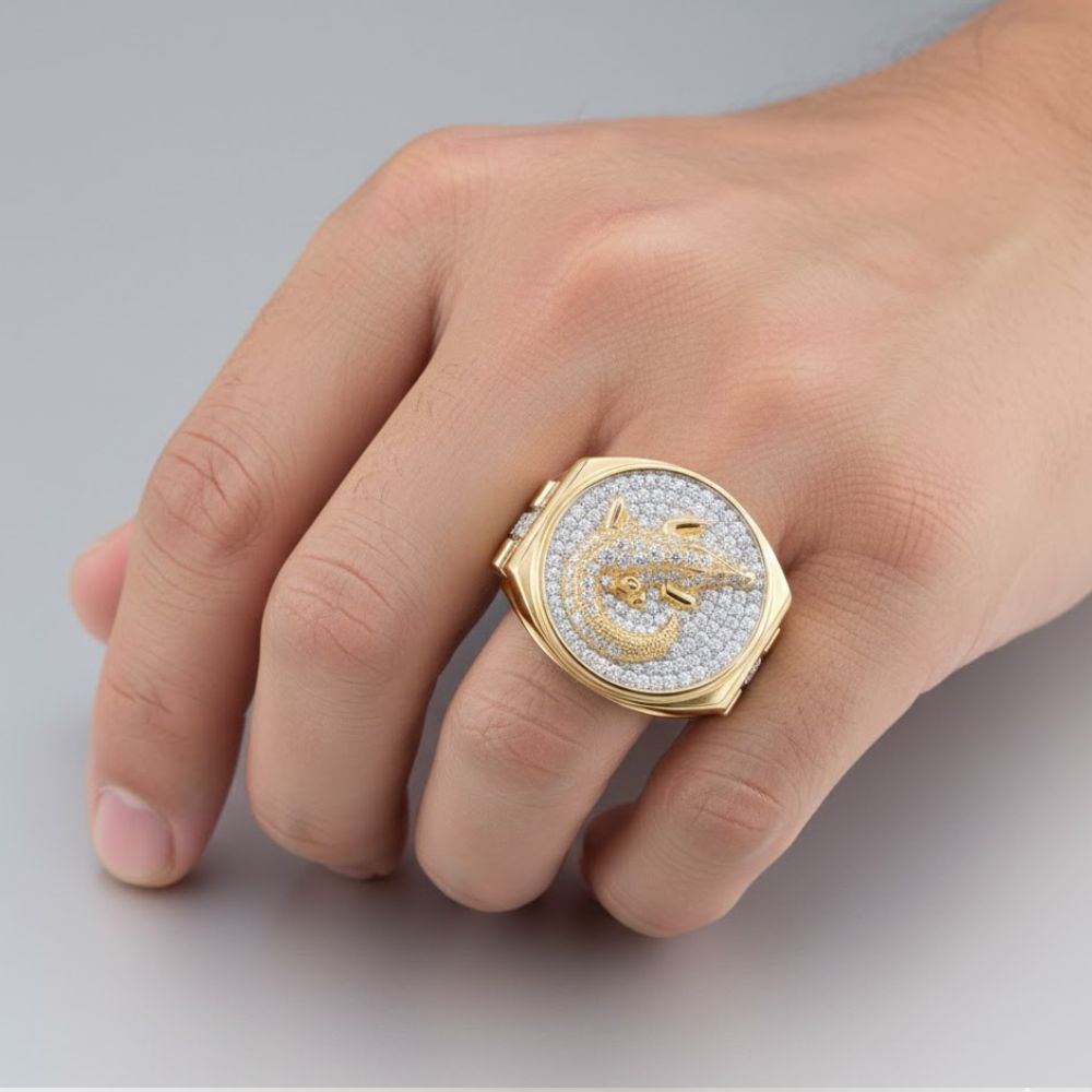 A hand displays the 1CTW Diamond Crocodile Men's Ring in 14k Gold, featuring a circular face with sparkling diamonds and a raised gold crocodile design at the center.