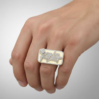 A hand displays the 10K Yellow Gold 2CT Diamond King Crown Ring, a bold men’s ring set with natural diamonds and featuring the word "KING" in striking letters across its face.
