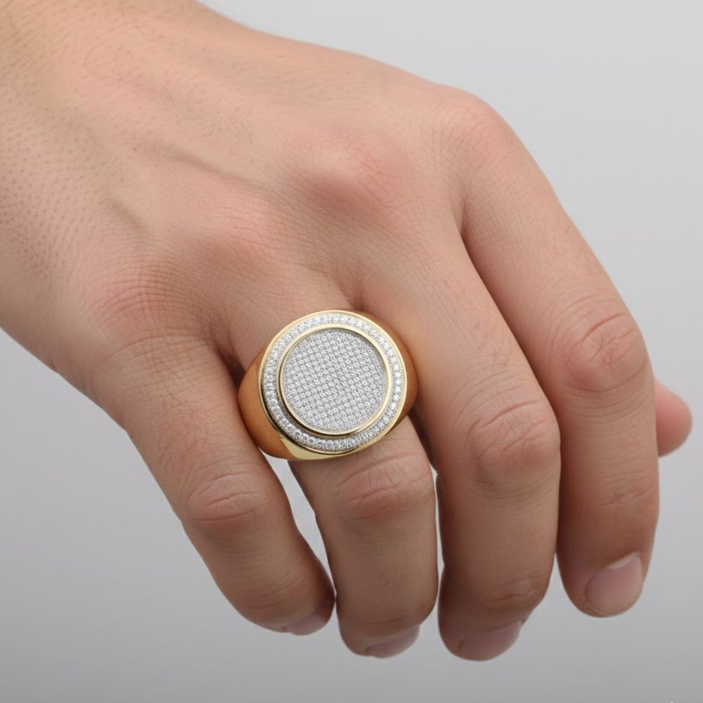 A hand showcases the 10k Yellow Gold Diamond Circle Frame Cluster Ring, featuring a silver center and a cluster of sparkling stones, worn elegantly on the middle finger against a plain light background.