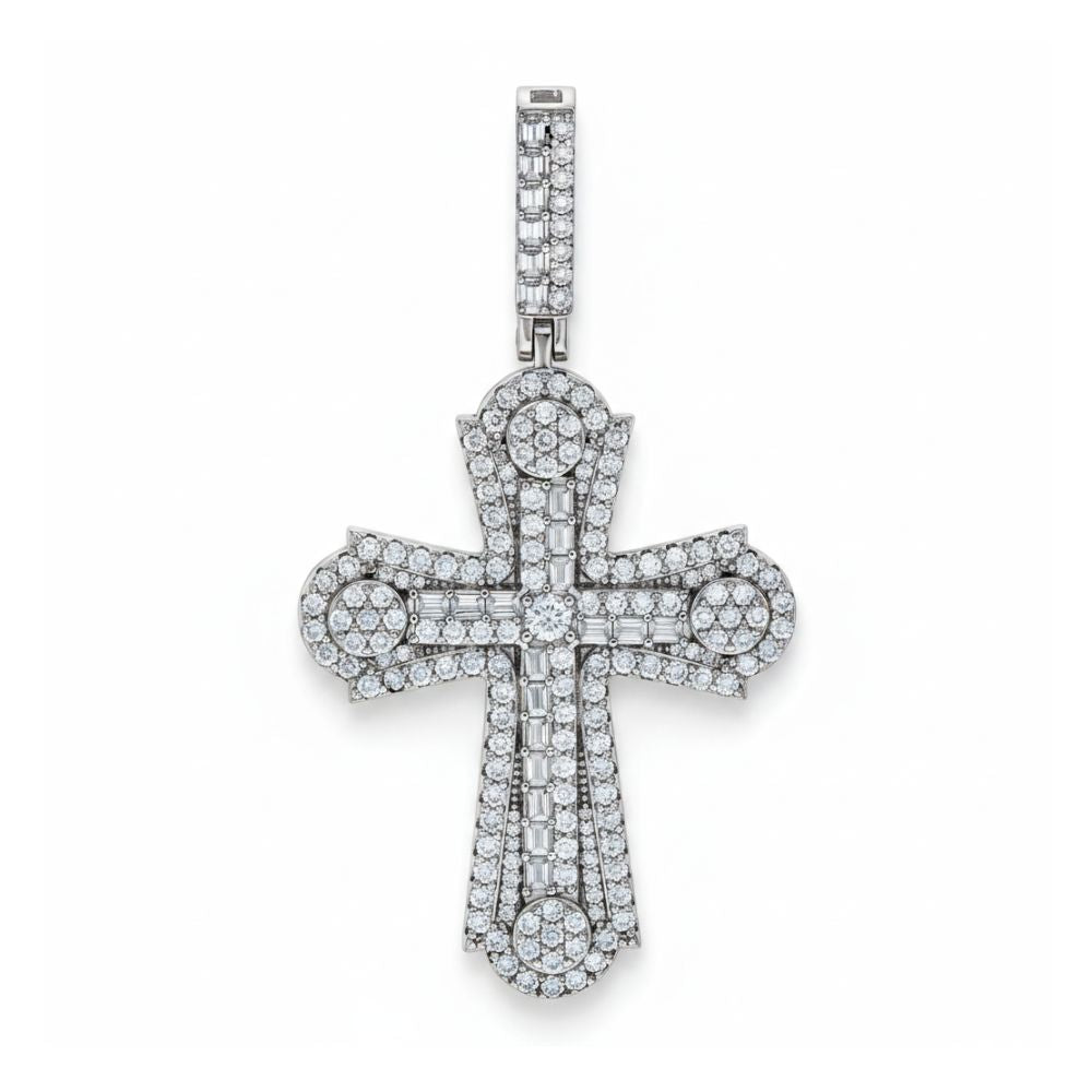 The Baguette Moissanite Cross Charm Pendant by GOLDZENN Jewelry is a sterling silver religious pendant with sparkling moissanite stones, detailed diamond-like accents, and a diamond-studded bail. Shown against a white background.