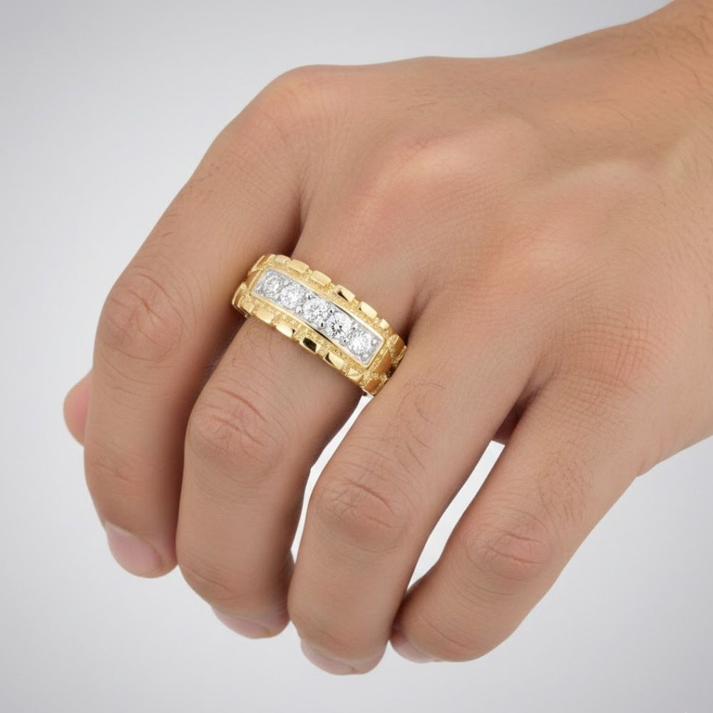 A hand displays the 1/2CTW Natural Diamond Nugget Men’s Ring in 10k gold, featuring a bold band with sparkling diamonds at the center, set against a plain light background.