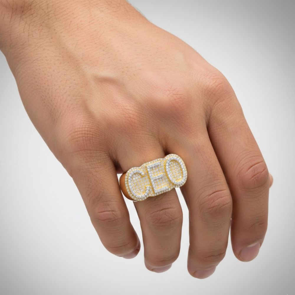 A hand showcases the 0.78 CTW CEO Natural Diamond cluster ring in 14K gold, featuring sparkling diamonds that spell "CEO" on the middle finger against a simple background.
