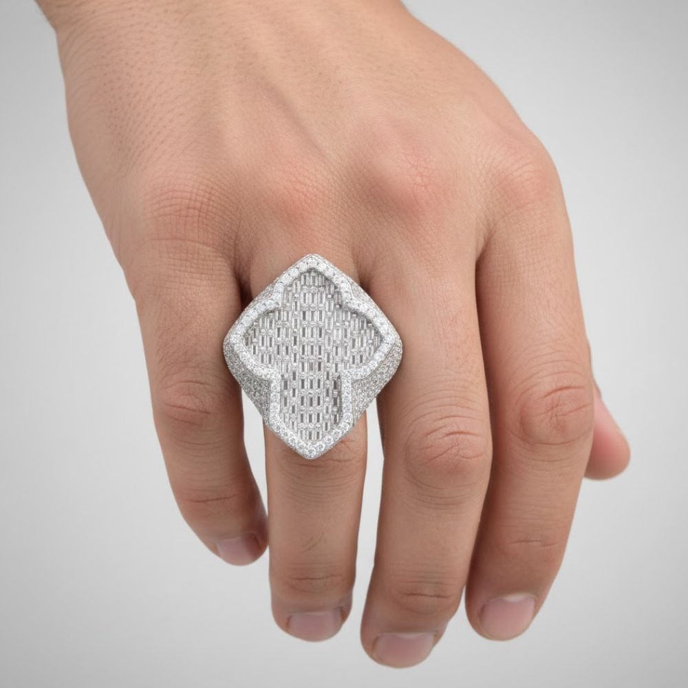 A hand wears the 5.82ct Baguette Moissanite Cross Religious Ring, a bold sterling silver piece featuring a square shape, intricate woven texture, shiny details, and a sparkling cross design.