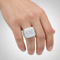 A hand wears the Moissanite KING Square Head Fashion Ring, featuring engraved ALC letters on sparkling stones, displayed on the middle finger.