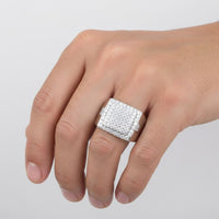 A close-up of a hand wearing the Silver Moissanite Signet Ring, a bold sterling silver ring adorned with sparkling moissanite stones, set against a plain light background.
