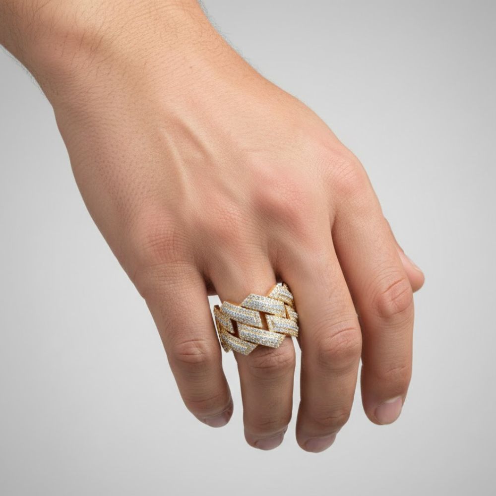 A hand displays the 10k Two-Tone Gold Round Diamond Band 1-3/8 Cttw, featuring a bold geometric zigzag design encrusted with diamonds, set against a plain light gray background.