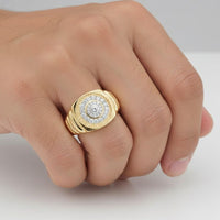 A close-up of a hand wearing the 14K Gold 1/2 CTW Natural Diamond Men’s Ring, featuring a circular design with concentric rows of small white diamonds set in yellow and white gold around a larger center stone.