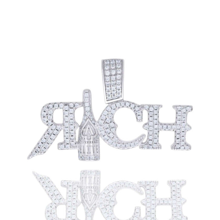 The Moissanite RICH Fashion Charm Pendant features diamond-studded letters spelling "RICH" with a champagne bottle as the I, photographed on a white background with its reflection—a true luxury statement piece.