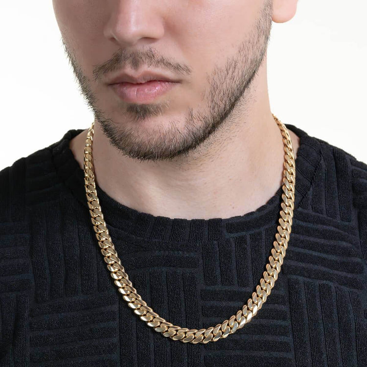 A man wears a black textured shirt and the Handmade Miami Cuban Link Chain—Solid Gold, Ready to Ship—shown from the shoulders up against a plain white background.