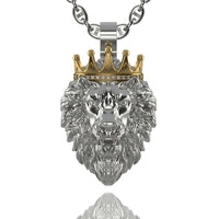 The Regal Lion Pendant with Crown - 14k Gold features a striking silver lion with a detailed mane and a gold crown adorned with gemstones, hanging from a silver chain and casting a shimmering reflection below.