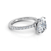 The Round Cut Lab Diamond Engagement Ring with Pave Band showcases a large round lab diamond in a four-prong white gold setting, accented by pavé-set diamonds along the band for added sparkle.