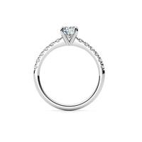 The Round-Cut Solitaire Lab Diamond Engagement Ring features a round lab diamond in a prong setting with small diamonds on the upper half of its white gold band, shown against a white background.