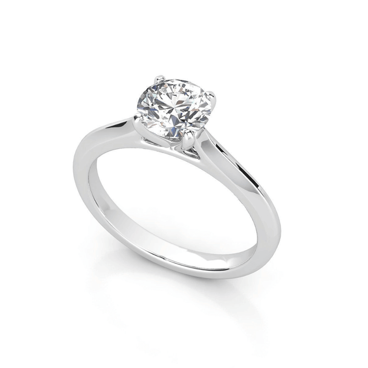 The Classic Round Solitaire Lab Grown Diamond Engagement Ring features a single round-cut lab diamond in a timeless four-prong setting, elegantly displayed on a white background.