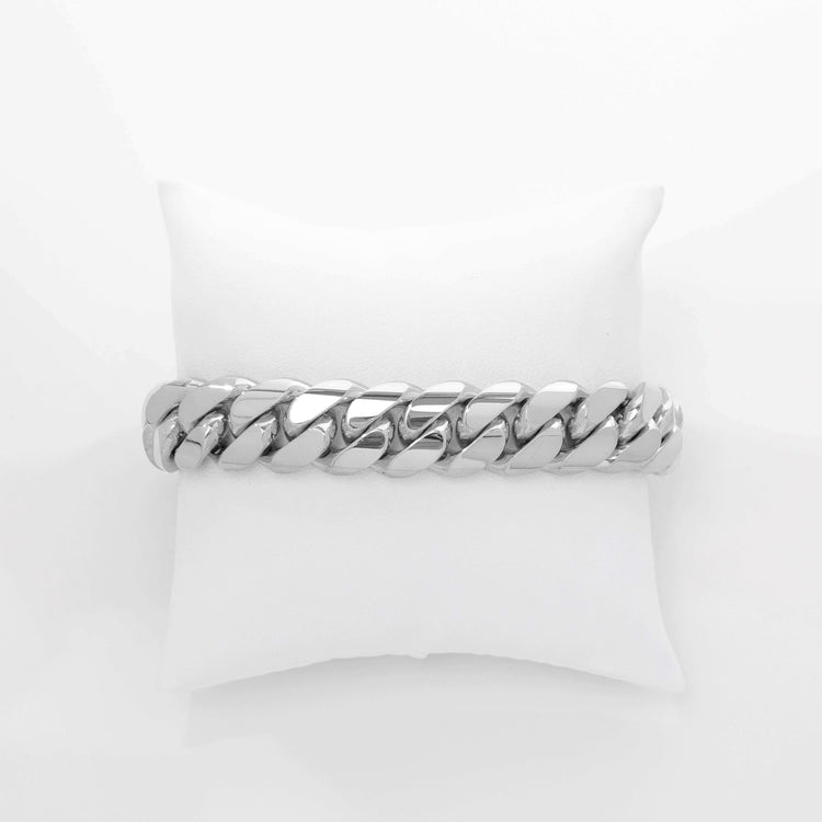 The 16mm Handmade Miami Cuban Link Bracelet, crafted from solid 950 silver, features a bold design and is displayed on a white cushioned stand against a plain white background.