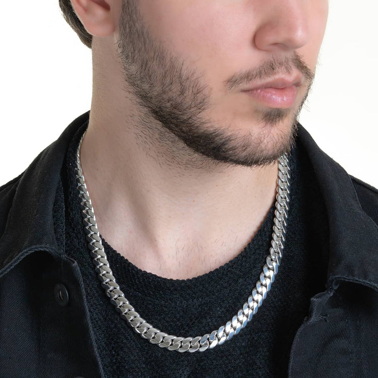 A close-up of a man's lower face and neck wearing the 10mm Handmade Miami Cuban Link Chain in 950 Silver, paired with a black jacket and shirt, set against a plain white background.