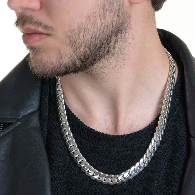 A man with a short beard wears a black knit shirt, black leather jacket, and a 12mm Handmade Miami Cuban Link Chain - 950 Silver. The image is cropped to show only his lower face and upper torso.