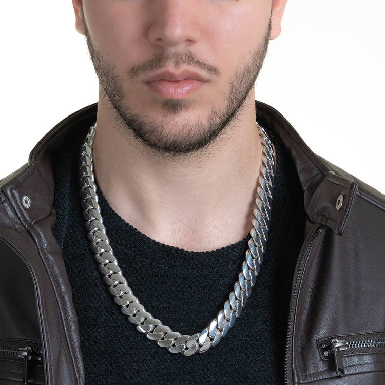 A man with a trimmed beard, dark sweater, brown leather jacket, and a bold 16mm Handmade Miami Cuban Link Chain in 950 Silver; only his lower face and upper torso are visible.