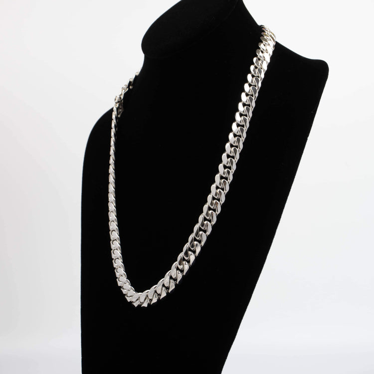 The 18mm Handmade Miami Cuban Link Chain in 950 silver, featuring flat interlocking links, is showcased on a black velvet necklace stand against a white background.