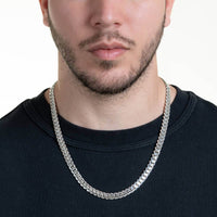 A man with light skin and short facial hair wears a plain black crewneck shirt and the Silver Cuban Link Chain - 8mm. The photo is cropped from nose to chest against a white background.