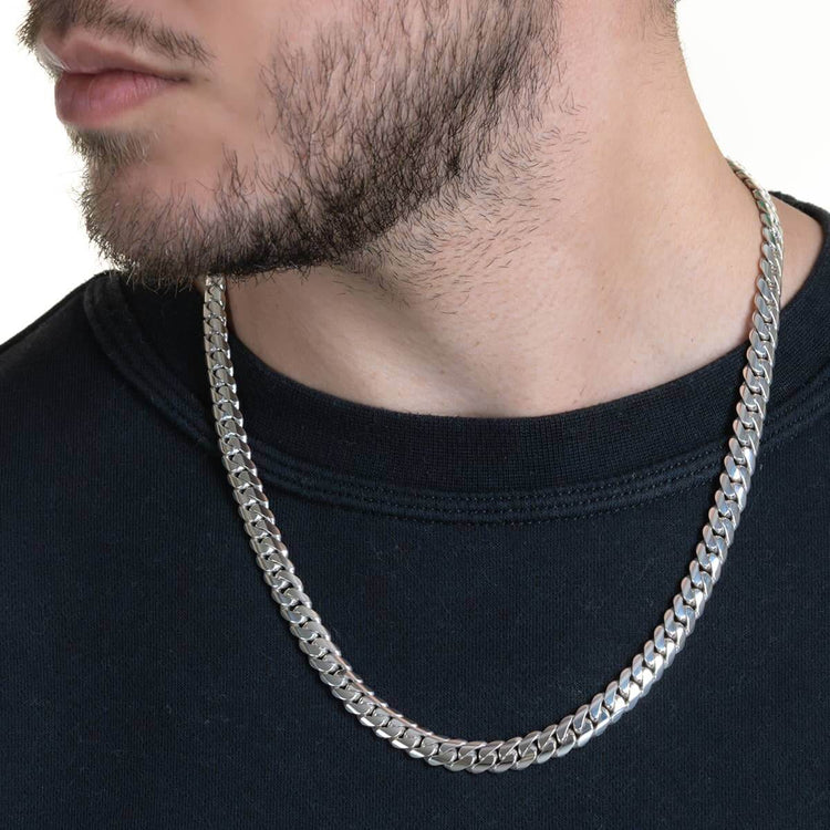 A close-up of a man’s neck and lower face wearing the 8mm Handmade Miami Cuban Link Chain - 950 Silver over a black crew-neck shirt.