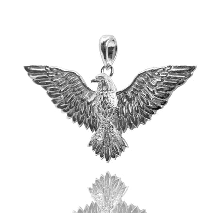 The Silver Eagle Pendant features outstretched wings, detailed feather engravings, and a loop for attaching to a chain, displayed against a white background with a subtle reflection.
