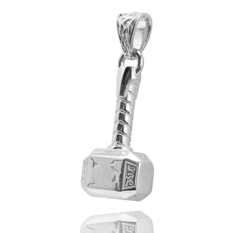 The Silver Hammer Pendant, crafted with detailed jewelry work and engraved markings on its head, is shaped like Mjolnir and displayed elegantly on a reflective white surface.