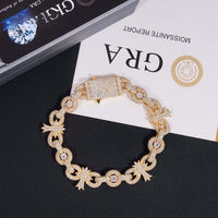 A gold diamond bracelet rests on black and white paper, paired beautifully with the Silver Moissanite Cross Infinity Bracelet for timeless elegance.